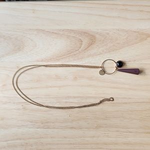 Necklace with a black charm and a purple cone-shaped rubber charm
